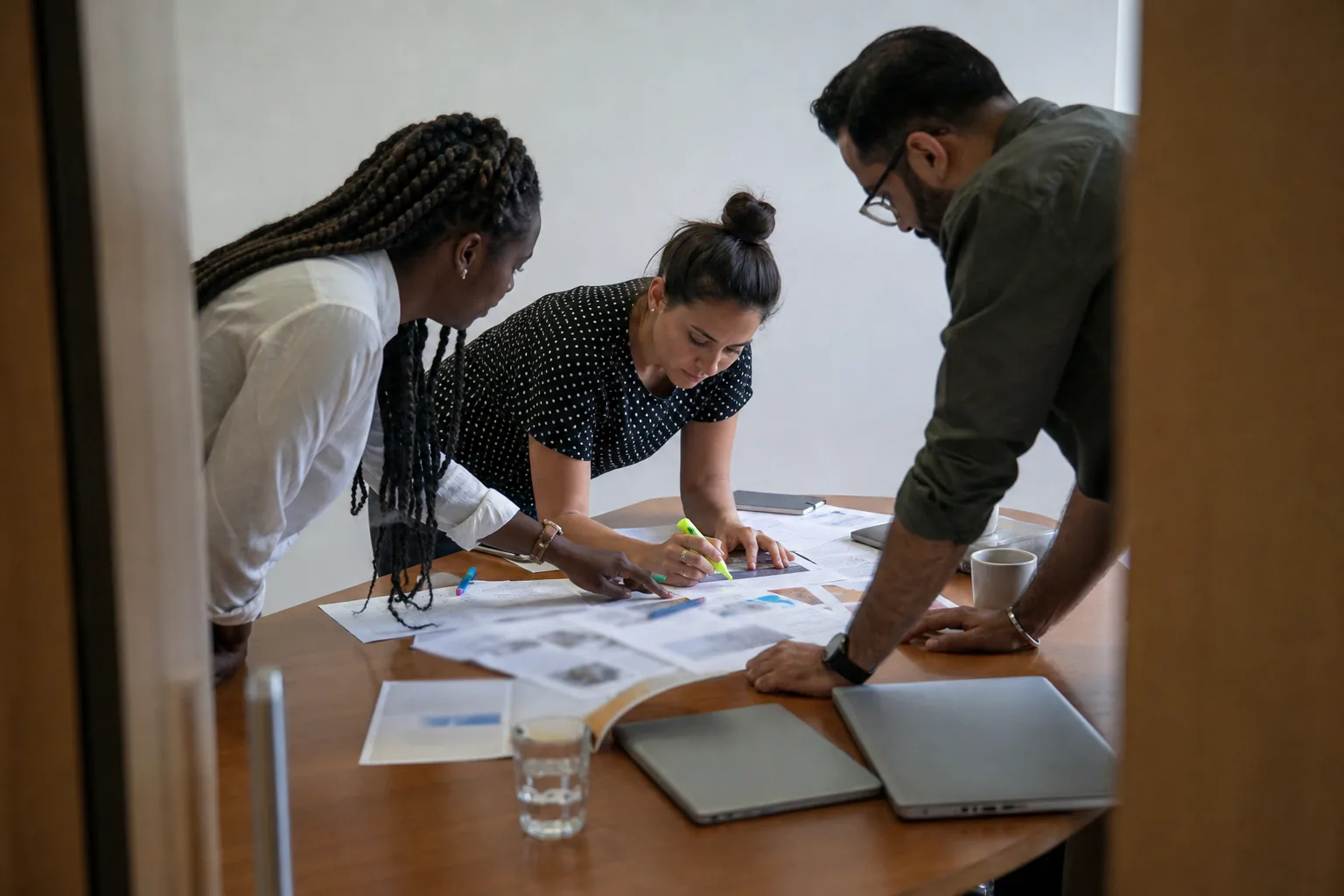Training team reviewing printed scripts in several languages around a meeting table